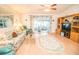 Bright living room boasts wood floors, floral sofa set, and sliding glass doors to the sunroom at 2060 Saffold Park Dr, Ruskin, FL 33570