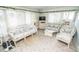 Inviting sunroom with casual rattan furnishings, white accents, and neutral carpet at 2060 Saffold Park Dr, Ruskin, FL 33570