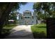 Charming two-story home with a bright blue exterior, solar panels, and a well-maintained front yard at 2321 Trelain S Dr, St Petersburg, FL 33712