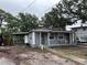 Residential home with exterior features including front porch, lawn, trees, and carport at 2354 7Th S St, St Petersburg, FL 33705