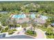 Aerial view of the community pool area with palm trees, golf carts and lush landscaping at 27546 Stonecreek Way, Wesley Chapel, FL 33544