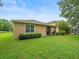 Exterior shot of the home's back side with lawn, shrubs, a window, and a covered patio at 27546 Stonecreek Way, Wesley Chapel, FL 33544
