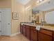 Bathroom with a double sink vanity featuring granite countertops and wood cabinets at 27546 Stonecreek Way, Wesley Chapel, FL 33544