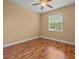 An empty bedroom with wood floors, base molding, ceiling fan and natural light from a window at 27546 Stonecreek Way, Wesley Chapel, FL 33544