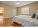 Inviting bedroom with neutral walls, laminate flooring, and a window for natural light at 27546 Stonecreek Way, Wesley Chapel, FL 33544