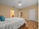 Bedroom with laminate floors, a ceiling fan, and open doorways to other areas of the home at 27546 Stonecreek Way, Wesley Chapel, FL 33544