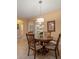 Dining area with a glass-top table, four chairs, tile flooring, complemented by natural light and neutral decor at 27546 Stonecreek Way, Wesley Chapel, FL 33544