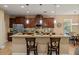 Kitchen bar with granite countertops, wood cabinets, pendant lights, stainless steel appliances, and tiled backsplash at 27546 Stonecreek Way, Wesley Chapel, FL 33544