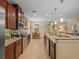 Gourmet kitchen features granite countertops, stainless steel appliances, dark wood cabinets, and tile backsplash at 27546 Stonecreek Way, Wesley Chapel, FL 33544