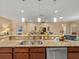 Open kitchen view showcasing granite countertops, stainless steel appliances and pendant lighting at 27546 Stonecreek Way, Wesley Chapel, FL 33544