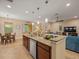 Open-concept kitchen with a granite countertop island, stainless steel appliances, and wood cabinetry at 27546 Stonecreek Way, Wesley Chapel, FL 33544