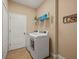 Laundry room with tile flooring and a modern, front-loading washer and dryer at 27546 Stonecreek Way, Wesley Chapel, FL 33544