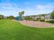 Community playground surrounded by green grass, mulch, lush landscaping and nearby homes at 27546 Stonecreek Way, Wesley Chapel, FL 33544