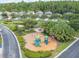 Aerial view of a charming community playground with lush landscaping in a desirable Gathering neighborhood at 27546 Stonecreek Way, Wesley Chapel, FL 33544