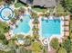 Aerial view of community pools, splash pad and lounging area amid lush surroundings at 27546 Stonecreek Way, Wesley Chapel, FL 33544
