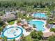 Aerial shot of a community pool, splash pad, with palm trees and various lounging options at 27546 Stonecreek Way, Wesley Chapel, FL 33544