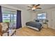 Bright bedroom with wood floors, ceiling fan, and sliding door leading to the outdoors at 301 Kings Blvd # 130, Sun City Center, FL 33573