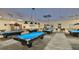 Large community billiards room with multiple pool tables and overhead lighting at 301 Kings Blvd # 130, Sun City Center, FL 33573