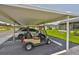 Carport showcasing a golf cart and parked car, offering covered parking and vehicle storage at 301 Kings Blvd # 130, Sun City Center, FL 33573