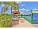 Outdoor pickleball court providing a recreational amenity with shade and seating, surrounded by lush landscaping at 301 Kings Blvd # 130, Sun City Center, FL 33573