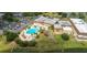 An aerial shot capturing a sparkling blue pool surrounded by lush greenery, lounge chairs, and umbrellas, perfect for relaxation at 301 Kings Blvd # 130, Sun City Center, FL 33573