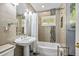 Bathroom featuring a pedestal sink, decorative tile accents, and a tub with shower at 3107 S Emerson St, Tampa, FL 33629