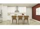 Modern kitchen featuring white cabinetry, stainless steel appliances, and a stylish center island at 32046 Griffin Sands Ln, San Antonio, FL 33576