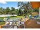 Backyard featuring a wooden deck with an outdoor dining set, blue seating and lush green lawn at 327 Sunnyside Rd, Temple Terrace, FL 33617