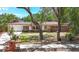 Charming home with brick accents, a well-manicured lawn, and mature trees at 327 Sunnyside Rd, Temple Terrace, FL 33617