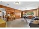 Open-concept living room and dining area with wood paneling, and lots of natural light at 327 Sunnyside Rd, Temple Terrace, FL 33617