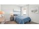 Cozy bedroom featuring a blue accent bedding set, carpet floors, and a large window with natural light at 33019 Osprey Peak Way, San Antonio, FL 33576