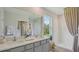 This bathroom has double sinks, a decorative plant and a shower at 33042 Osprey Peak Way, San Antonio, FL 33576