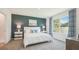 Stylish bedroom with a navy accent wall, white bedding, and ample natural light at 33050 Osprey Peak Way, San Antonio, FL 33576