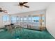 Living room with green carpet, ceiling fans, and large windows showcasing waterfront views at 333 Midway Is, Clearwater Beach, FL 33767
