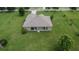 Back of home from drone showcasing the back porch, green lawn, and mature landscaping at 3411 Knoxville Pl, Plant City, FL 33566