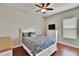 Charming bedroom with a ceiling fan, featuring a white bed frame and dresser, accented by a hardwood floor at 3411 Knoxville Pl, Plant City, FL 33566