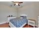 Cozy bedroom with a ceiling fan, complemented by a white bed frame and dresser, atop hardwood floors at 3411 Knoxville Pl, Plant City, FL 33566