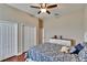 Inviting bedroom featuring a white bed frame, ceiling fan, and closet space for a blend of style and functionality at 3411 Knoxville Pl, Plant City, FL 33566
