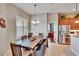 Dining area with a large wooden table, shuttered window, and adjacent access to the kitchen at 3411 Knoxville Pl, Plant City, FL 33566