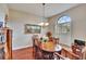 Traditional dining room features a wood table and chairs, hardwood floors, and natural light from a window with shutters at 3411 Knoxville Pl, Plant City, FL 33566
