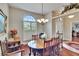 Charming dining room boasts a wooden table with chairs, hardwood floors, and natural light from a window with shutters at 3411 Knoxville Pl, Plant City, FL 33566