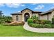 Inviting home entrance with stone archway, front fountain and lush landscaping at 3411 Knoxville Pl, Plant City, FL 33566