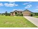 Charming home with a well-manicured lawn, fountain and a two-car garage on a sunny day at 3411 Knoxville Pl, Plant City, FL 33566
