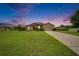 Charming home with a well-manicured lawn, fountain and a two-car garage at sunset at 3411 Knoxville Pl, Plant City, FL 33566