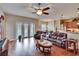 Bright living room features hardwood floors, an open layout, leather furniture, and French doors leading outside at 3411 Knoxville Pl, Plant City, FL 33566