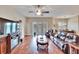 Open living room with hardwood floors, a ceiling fan, a leather sofa, and French doors to the patio at 3411 Knoxville Pl, Plant City, FL 33566