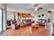 Spacious living room with hardwood floors, leather furniture, and an open layout into the kitchen at 3411 Knoxville Pl, Plant City, FL 33566