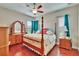 Bedroom boasts a four-poster bed, wood floors, two windows, and curtains at 3411 Knoxville Pl, Plant City, FL 33566