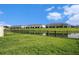 A lovely row of townhomes borders a serene pond, framed by a lush green lawn with a black iron fence at 3528 Maple Grove Way, Plant City, FL 33565