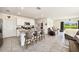 Kitchen island featuring granite countertops, barstool seating, and views to the living room at 3528 Maple Grove Way, Plant City, FL 33565